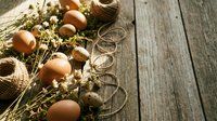 Fresh brown eggs nestled in natural straw and twine on rustic wooden planks, perfect for organic farm branding and country kitchen decor projects.
