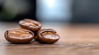 Fresh roasted coffee beans with rich brown color and natural sheen on rustic wooden surface, macro photography showing detailed texture and aroma for cafe marketing.