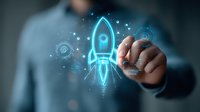 Glowing blue neon rocket hologram with digital elements drawn by businessman in suit, representing startup launch and business growth concept.