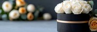 Elegant white roses in luxury black gift box with gold ribbon, romantic floral arrangement for special occasions and celebrations.