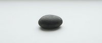 Smooth dark gray stone pebble isolated on white background, suitable for wellness, spa, meditation, and design projects.