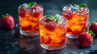 Refreshing strawberry cocktails with fresh berries, mint leaves and ice cubes on dark background. Vibrant orange-red summer drinks for bar menu or party.
