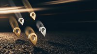 Golden location pins with glowing light trails on dark textured surface for navigation and mapping applications in business presentations.