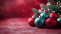 Festive holiday ornaments in red and teal arranged on textured pink surface with bokeh lights, perfect for seasonal marketing, greeting cards, and holiday promotional materials.