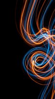 Dynamic light trails in orange and blue creating swirling energy patterns on black background for modern digital art and technology designs.