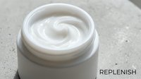 Creamy white moisturizer or skincare product in open jar with swirled texture, ideal for cosmetics, beauty, and wellness marketing materials.
