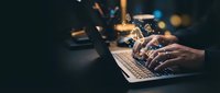 Professional hands typing on laptop with digital network connections and glowing data streams representing modern technology and online communication.