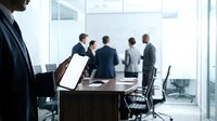 Professional businessman holding tablet in modern conference room with blurred team meeting in background. Corporate office environment for business presentations.