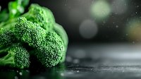 Fresh green broccoli florets on dark background with water drops and bokeh effect, macro food photography for healthy eating and nutrition concept.