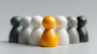 Yellow wooden pawn figure standing out among white and black pawns on neutral background, representing leadership and individuality.