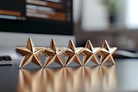 Five metallic copper-colored stars in row casting shadows on dark surface, representing excellence rating, achievement and quality evaluation system.