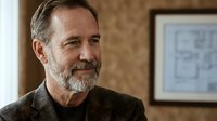 Mature man with gray beard and brown shirt looking thoughtfully to the side in warm interior setting, suitable for business, lifestyle, and editorial projects.
