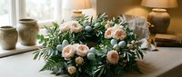 Fresh peach roses and eucalyptus arrangement on rustic wooden table with ceramic pottery in warm natural light for home decor and floral design projects.