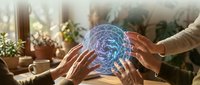 Hands reaching toward glowing digital brain hologram representing artificial intelligence, machine learning and neural networks in modern workspace.