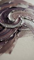 Abstract swirled paint texture in purple and brown tones with thick brushstrokes on canvas surface for artistic backgrounds and creative projects.