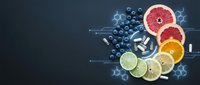 Fresh citrus fruits sliced with blueberries on dark background for healthy nutrition and vitamin C supplement concepts.