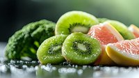 Sliced kiwi fruit and grapefruit with water droplets on wet surface, fresh tropical fruits for healthy eating, nutrition and wellness content.