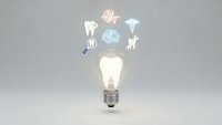 Glowing light bulb with floating medical icons including tooth, brain, DNA, stethoscope and heart symbols representing healthcare innovation concepts.