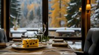 Elegant restaurant table setting with cheese plate and wine glasses against snowy mountain backdrop through panoramic window, creating cozy winter atmosphere.