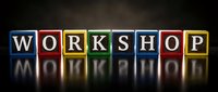 Colorful letter blocks spelling WORKSHOP with dramatic lighting and reflection on dark surface for business training and educational concepts.