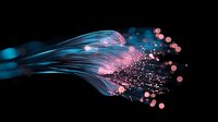 Glowing fiber optic strands emit blue light while pink particles and bokeh effects scatter against dark background creating magical technological atmosphere.