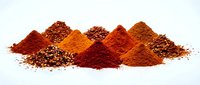 Colorful spice powder piles with seeds isolated on white background for culinary cooking and seasoning applications.