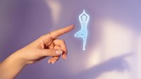 Hand pointing at glowing yoga pose silhouette on purple background. Meditation wellness concept for mindfulness apps and spiritual health content.