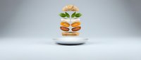 Floating burger ingredients separated in mid-air showing beef patties, cheese, lettuce and bun layers on white plate against gray background.