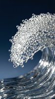 Macro shot of a crystal clear water wave curling with sparkling droplets and bubbles on a deep blue background, capturing fluid motion.