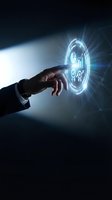 Businessman hand touching glowing holographic interface with business icons and light rays on dark background for digital transformation concepts.