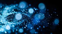 Blue glittering particles with bokeh light effects on dark background creating magical sparkle atmosphere for luxury design projects.
