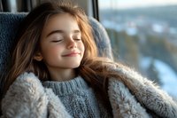 Young woman with closed eyes relaxing in cozy knit sweater and warm fuzzy blanket by window, expressing peaceful contentment and serenity on winter day.