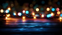 Colorful bokeh lights creating warm festive atmosphere over wooden surface for holiday celebrations and seasonal decorations.