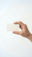 Hand holding blank white business card mockup on clean background for branding and corporate identity design projects.