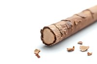 Chocolate wafer roll with crispy coating partially unwrapped showing creamy filling inside, with scattered pieces of chocolate shell on white background.