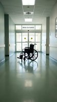 Empty wheelchair in hospital corridor near main entrance with polished floors and fluorescent lighting for healthcare accessibility concepts.