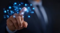 Professional in dark suit touching virtual interface with glowing blue digital icons floating in space, demonstrating modern technology interaction and data management.