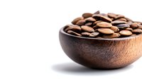 Roasted coffee beans in wooden bowl on white background, highlighting rich brown tones and natural texture for food and beverage marketing.