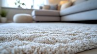 Soft plush carpet texture in modern living room interior with beige sofa and houseplants, close-up view showing luxurious pile and comfort for home decor.