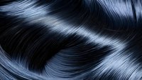 Luxurious dark hair with silky smooth texture and natural shine flowing in elegant waves for beauty and haircare concepts.