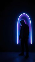Silhouette of young man standing in glowing neon arch with purple and blue lighting effects on dark background for modern design projects.