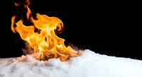 Dramatic orange flames dancing on white snow against black background creating striking contrast between fire and ice elements for creative projects.