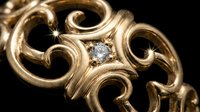 Elegant gold jewelry with ornate scrollwork and sparkling diamond center stone on black background for luxury fashion and accessories design.