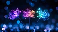 Glowing magical dandelions with sparkles in pink, orange and blue colors against dark bokeh background create dreamy nature atmosphere.