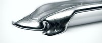 Metallic liquid metal substance flowing and dripping from silver spoon on white background, suitable for cosmetics, skincare, and product packaging design.