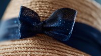 Elegant straw sun hat with navy blue ribbon bow, summer fashion accessory for beach vacation, outdoor style, women's headwear for sunny days and resort wear.