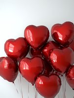 Red heart-shaped foil balloons clustered together against white background, perfect for Valentine's Day, anniversary, or romantic celebration.