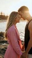 Young couple sharing intimate moment at sunset by water, romantic connection with golden hour lighting for relationship and love concepts.