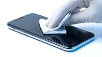 Gloved hand cleaning smartphone screen with microfiber cloth on white background, isolated device maintenance and hygiene for tech care and sanitation purposes.