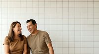 Young couple, Caucasian ethnicity, smiling and looking at each other against white grid background. Represents happiness, connection, and relationship moments for lifestyle and dating content.